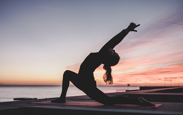 Woman stretching at sunrise